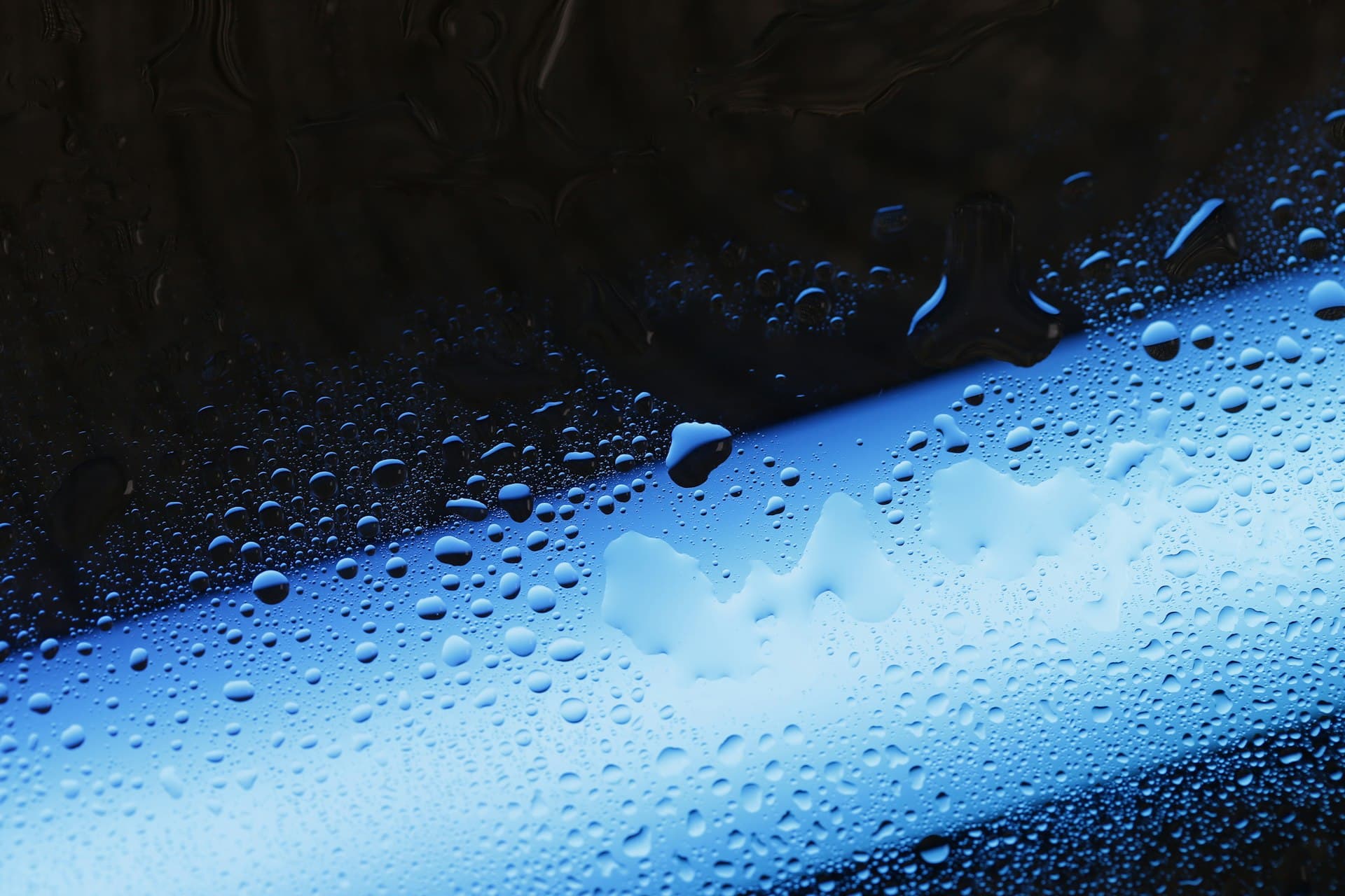 Water droplets on a blue illuminated surface, evoking the light-driven radical chemistry of advanced oxidation