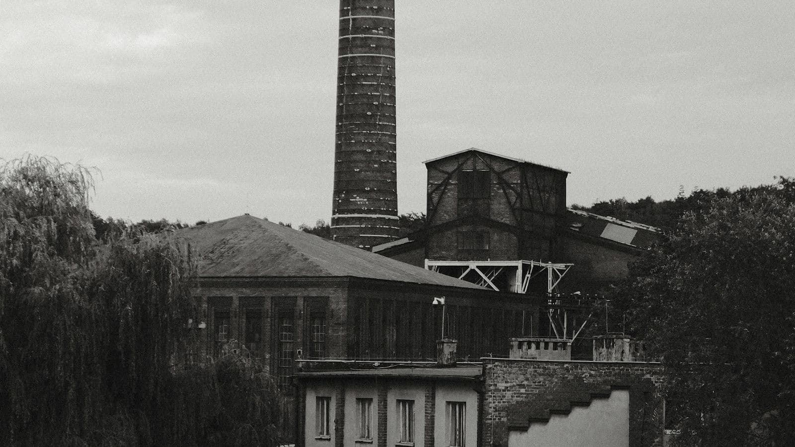 Industrial process tower with vertical column architecture under overcast sky, representing the packed-column and sieve-tray air stripper configurations used for VOC removal in groundwater remediation and industrial process water