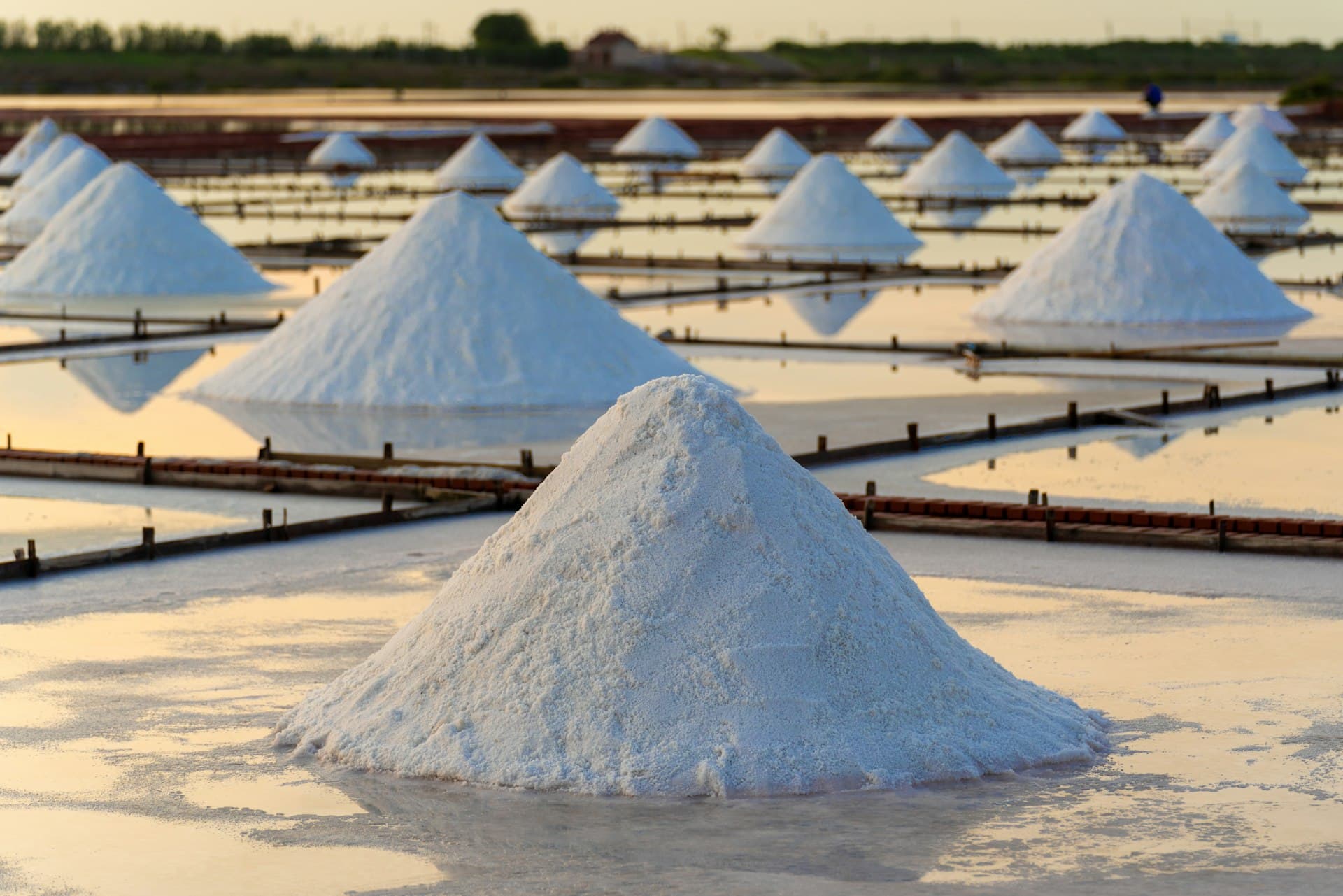 Harvested salt piles on a tiled salt field — recovering saleable product from concentrated brine
