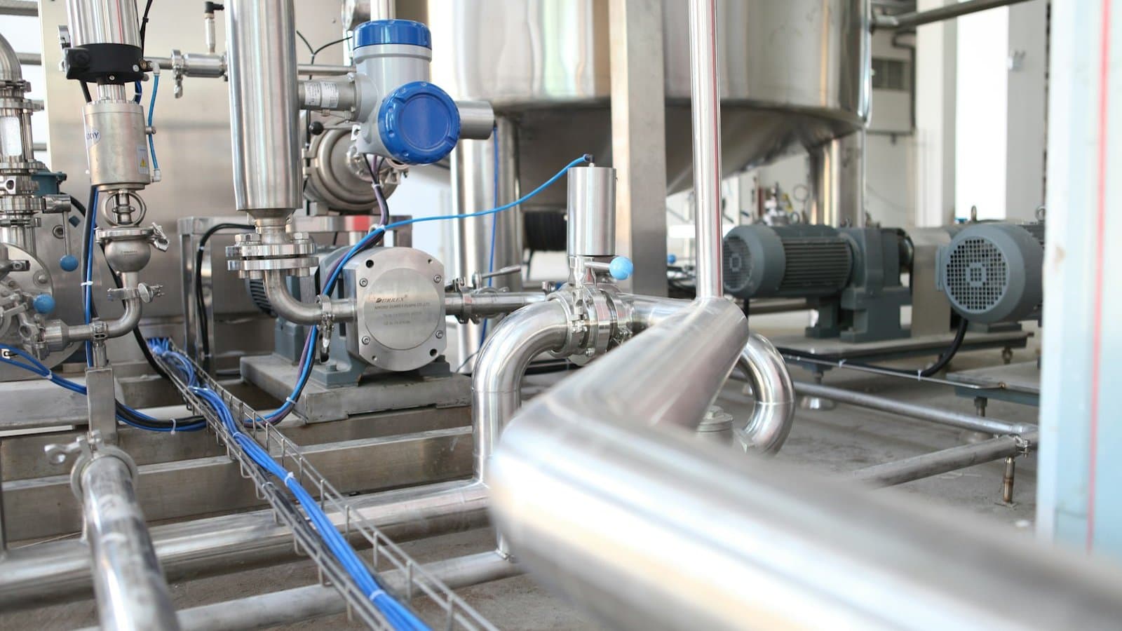 Grey industrial equipment and machinery in a commercial building services plant room