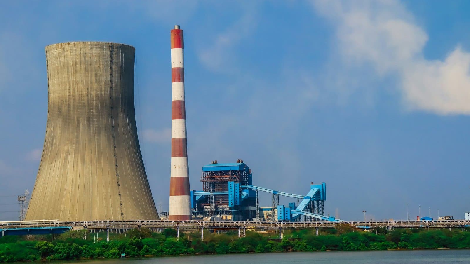 Hyperbolic cooling tower and stack at a power station — blowdown control governs the recirculating water chemistry