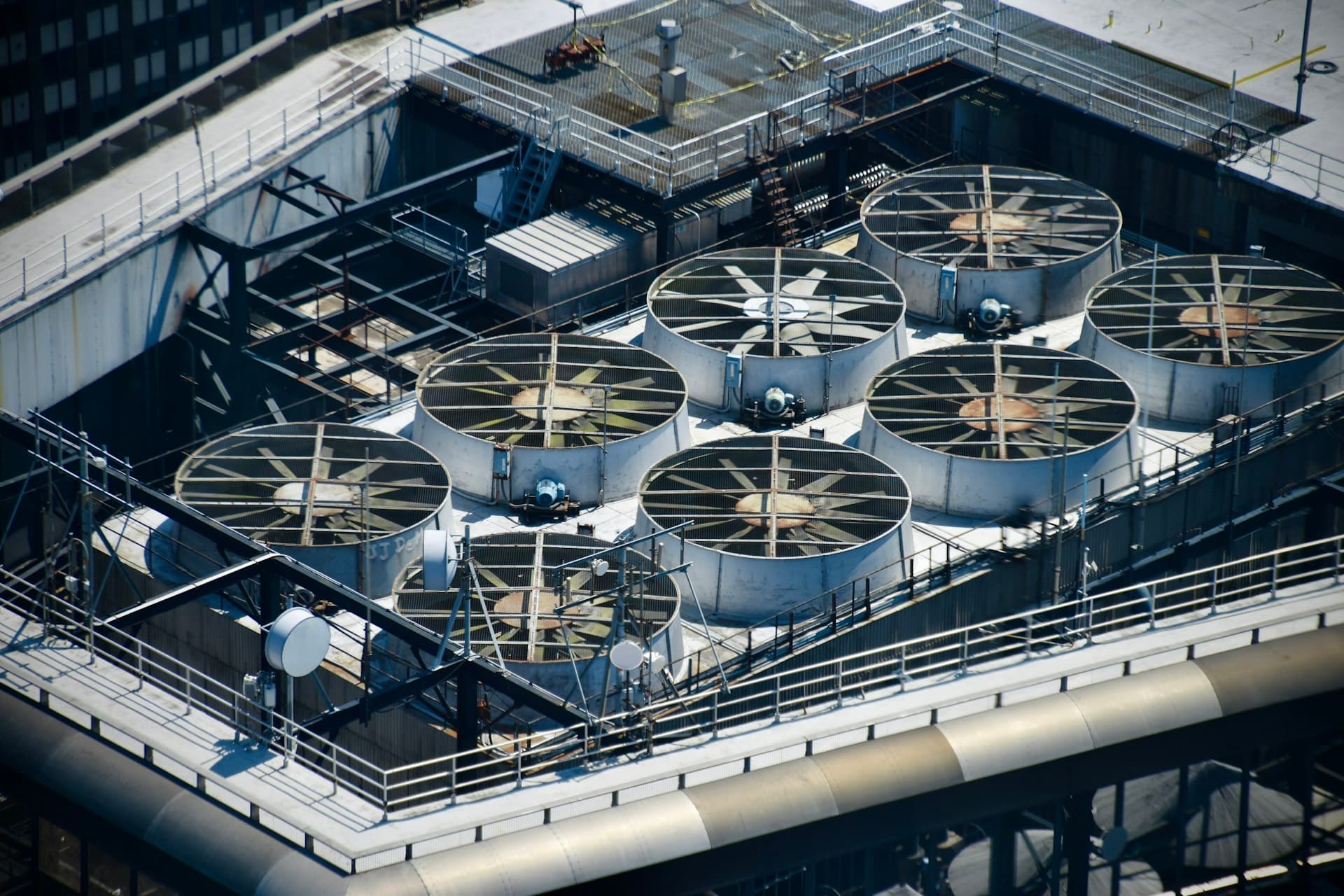 Bank of rooftop cooling tower cells with axial fans seen from above