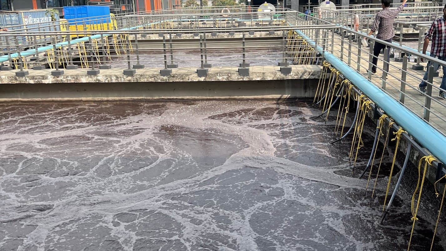 Aeration basin in full operation at an industrial effluent treatment plant, with fine-bubble diffusers churning the mixed liquor