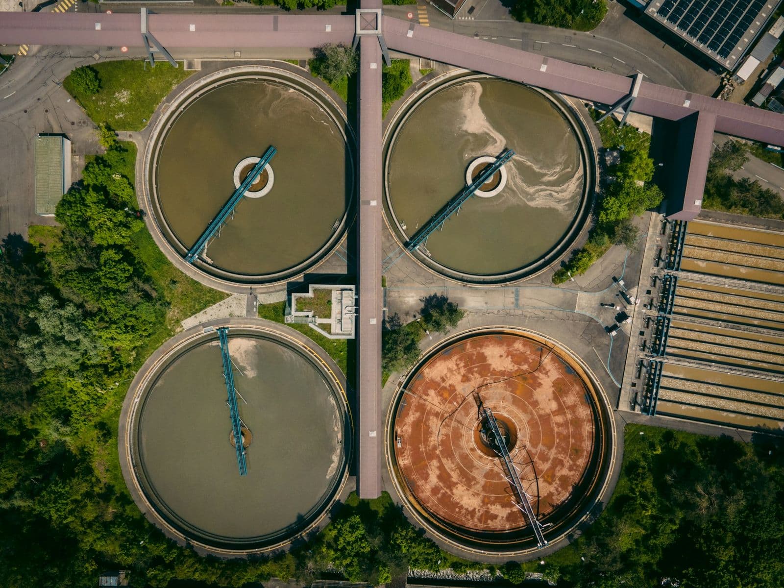 Aerial view of treatment basins in visibly different stages of coagulation and settling