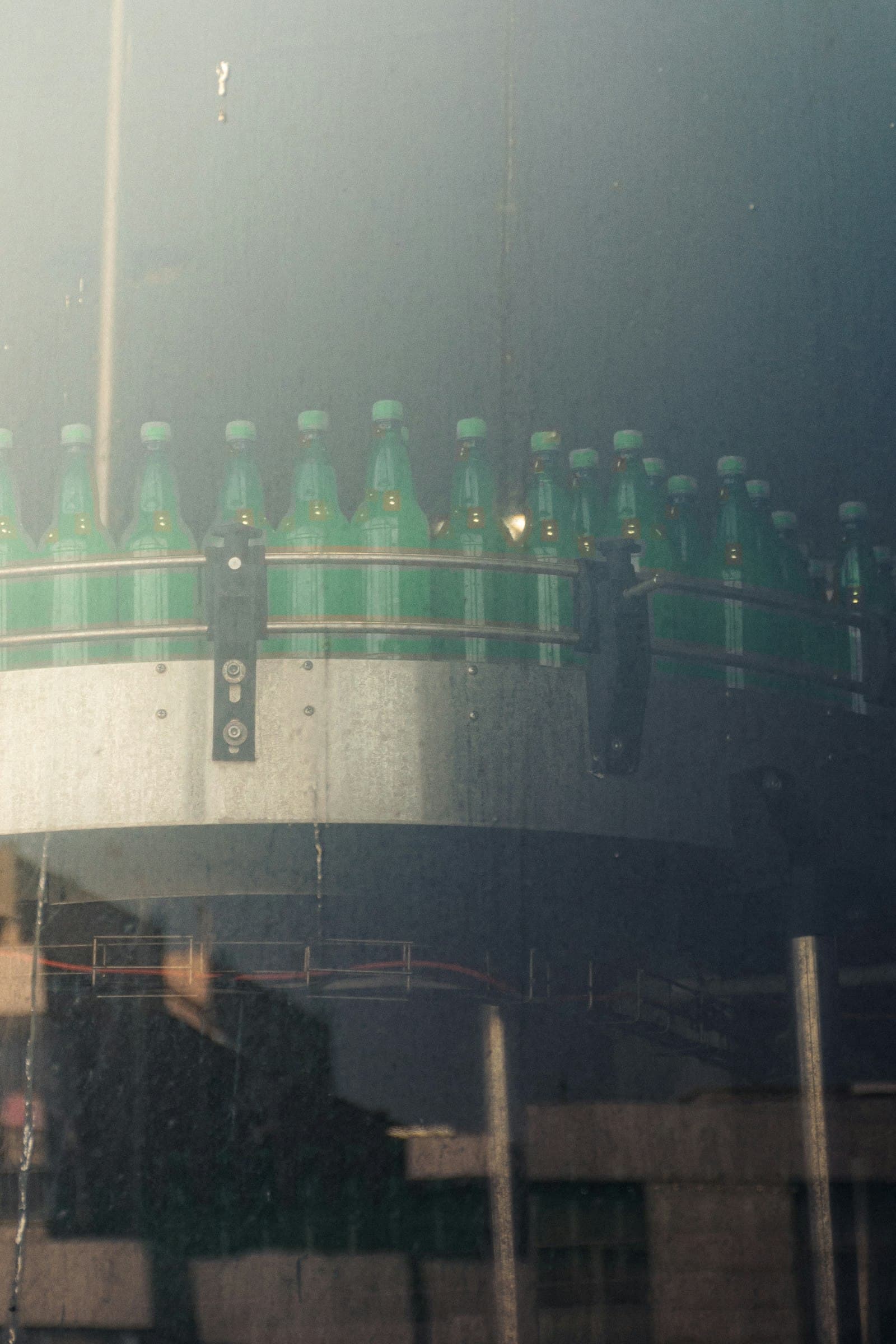 Green beverage bottles moving along a bottling line at a food and beverage plant