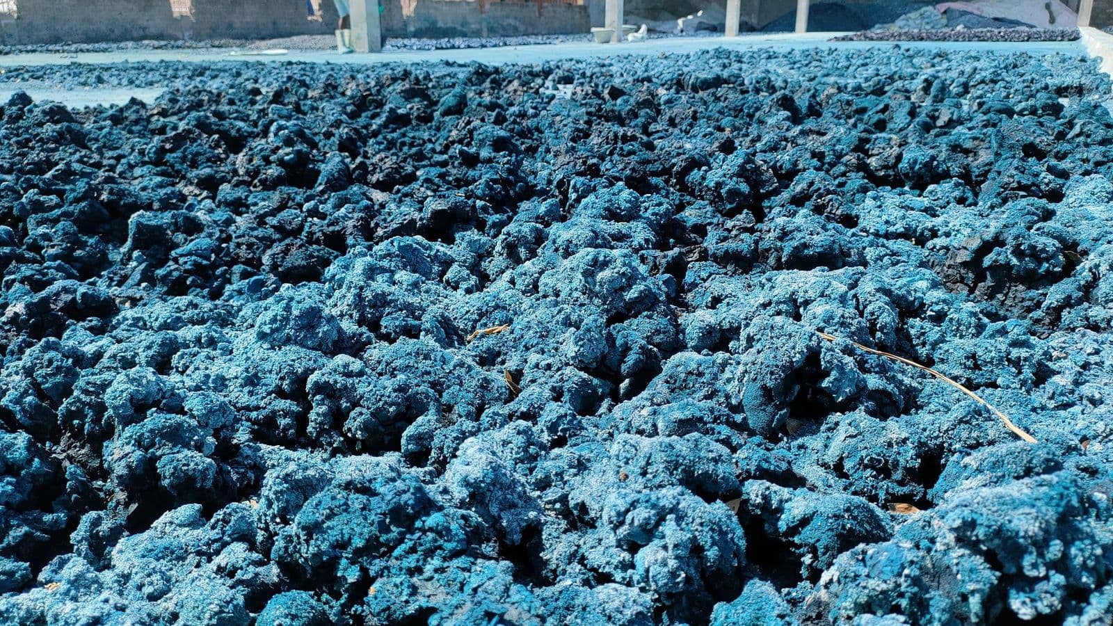 Mounds of blue dye-laden chemical sludge awaiting disposal at a textile plant — every kilogram carries haulage and landfill cost