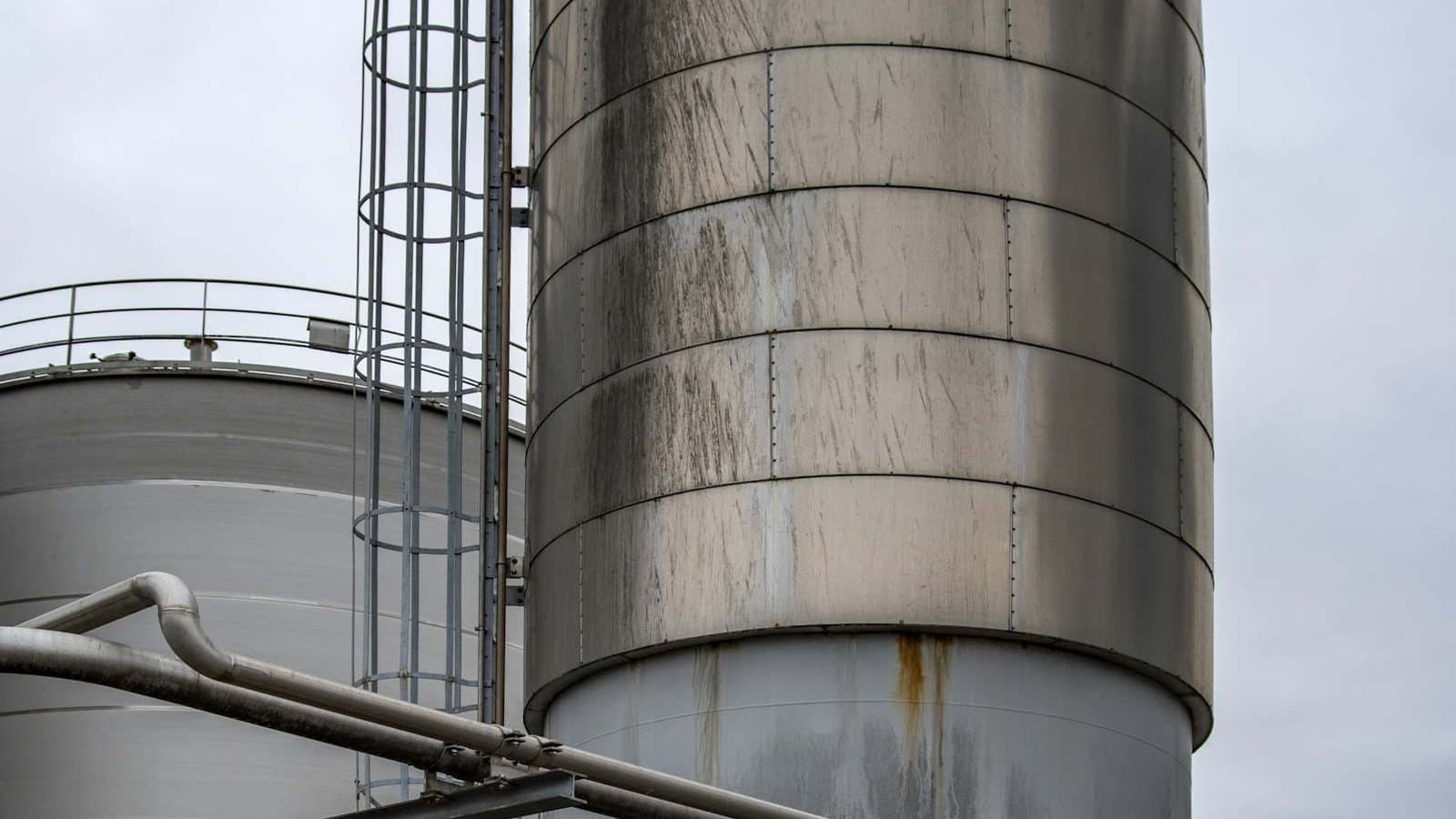 Gray industrial factory complex under a white sky, the kind of processing facility where the right water treatment technology selection determines operational reliability and cost