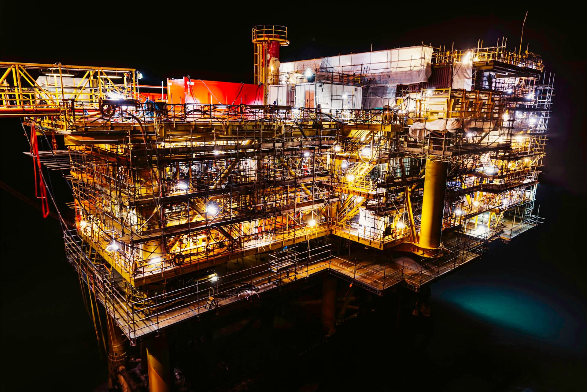 Offshore production facility lit at night, where induced gas flotation polishes produced water