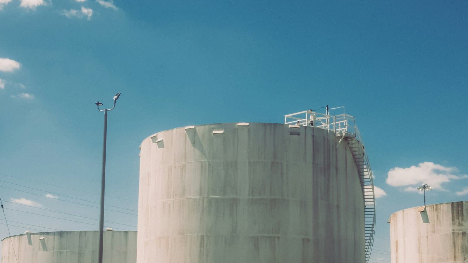Large industrial storage tanks under a clear blue sky at a commercial facility showing bulk water infrastructure