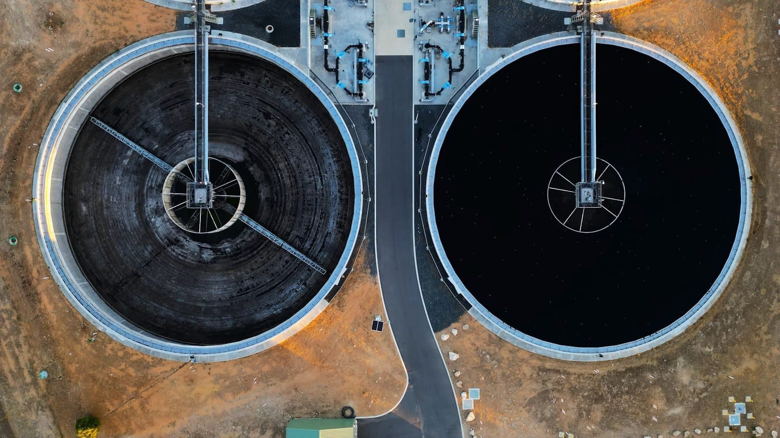 Aerial view of two large black industrial tanks at a process facility, the scale of cooling and storage infrastructure typical in data centre and manufacturing chiller plants