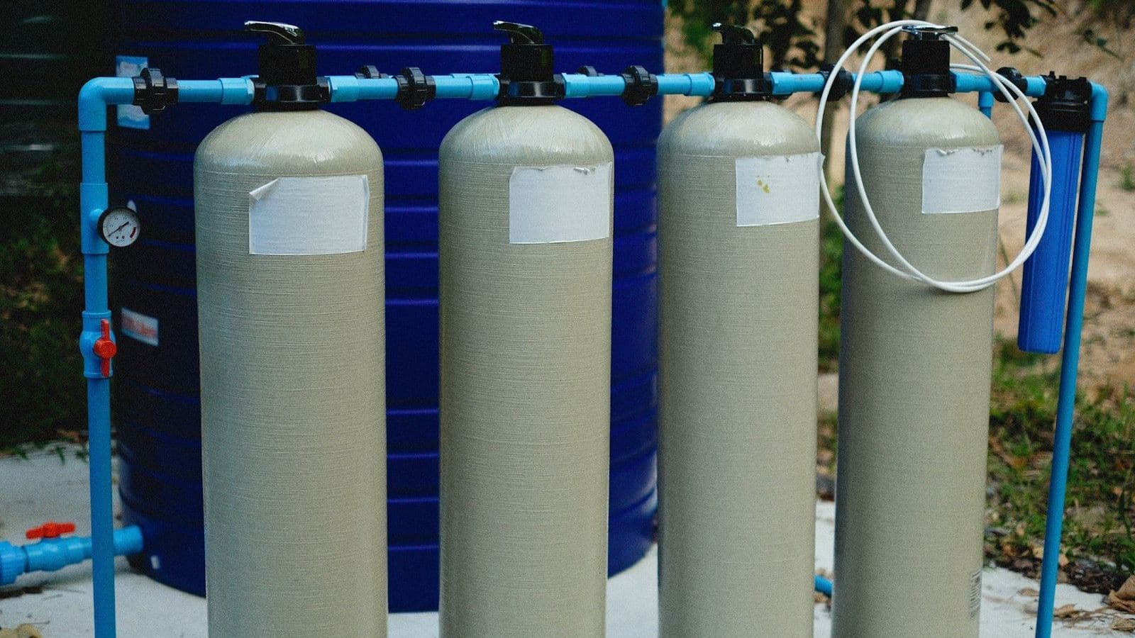 A pair of industrial water treatment tanks in a plant room, the ion exchange vessels at the heart of industrial water softening systems