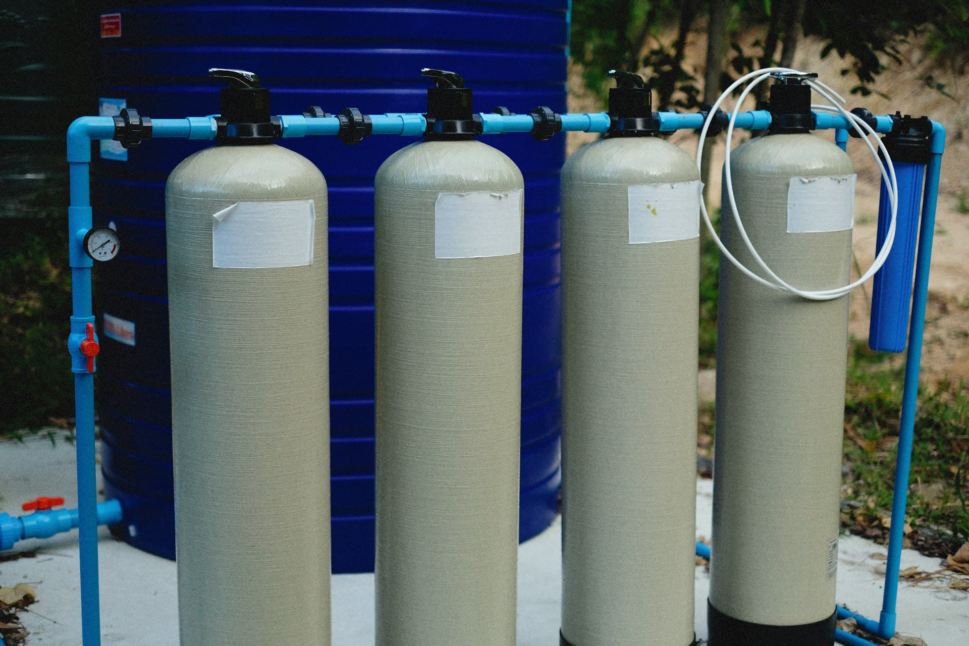 Bank of FRP ion-exchange vessels with blue cartridge housings plumbed for service and regeneration