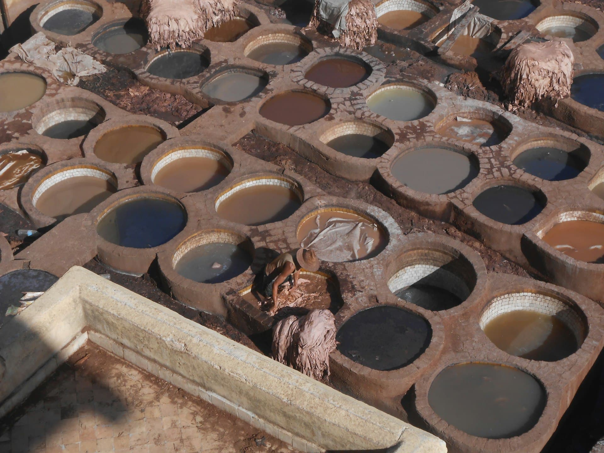 Stone dye and tanning pits filled with coloured liquors at a traditional tannery