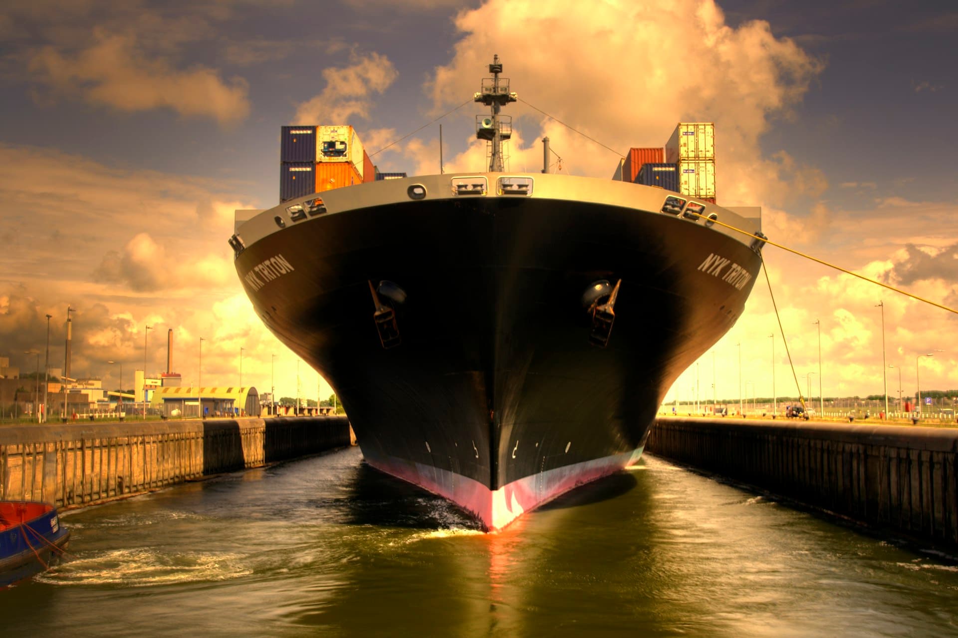 Bow of a cargo ship in golden light — exhaust scrubbers turn air emissions into a washwater stream