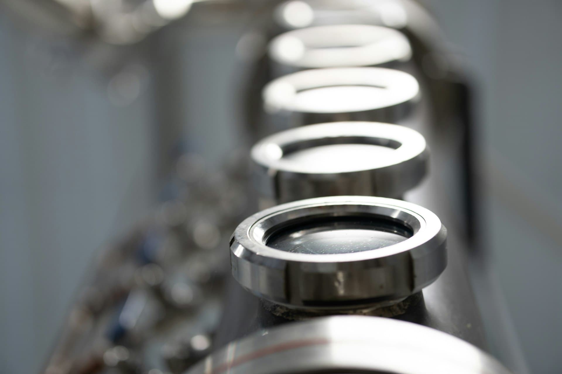 Row of polished stainless pipe fittings of a sanitary microfiltration line