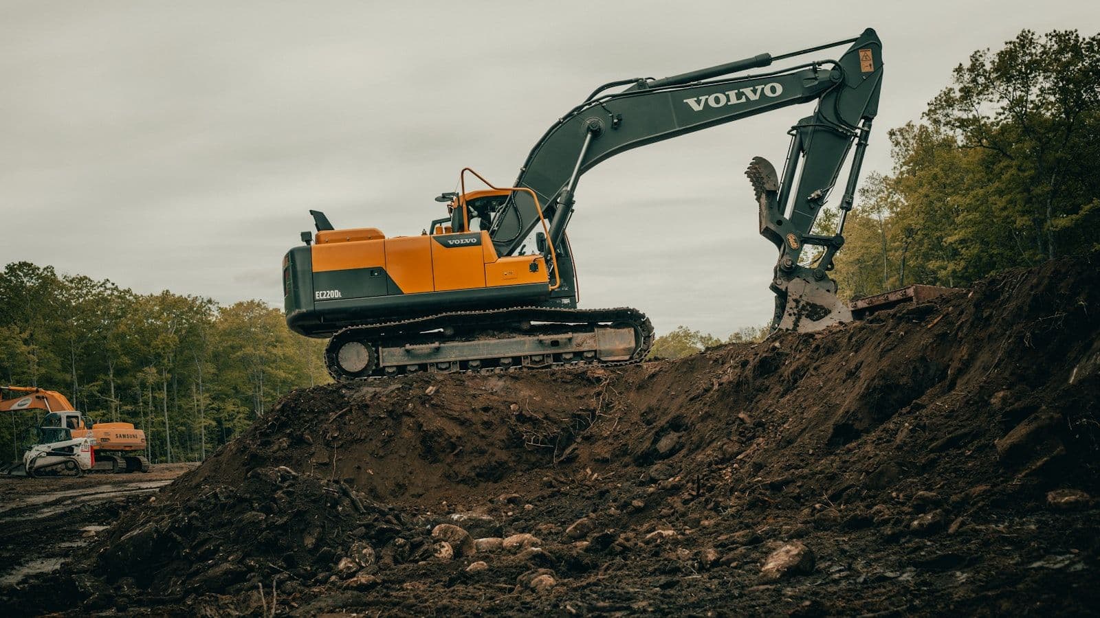 Orange and white excavator on a civil construction site preparing ground for underground stormwater detention infrastructure