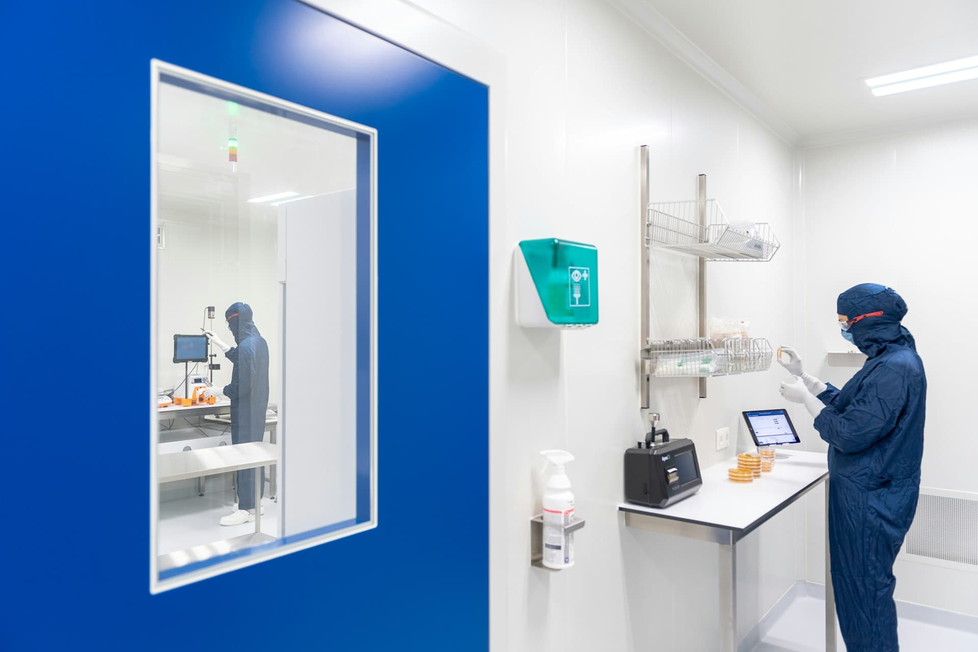 Cleanroom monitoring station behind a blue door at a pharmaceutical facility