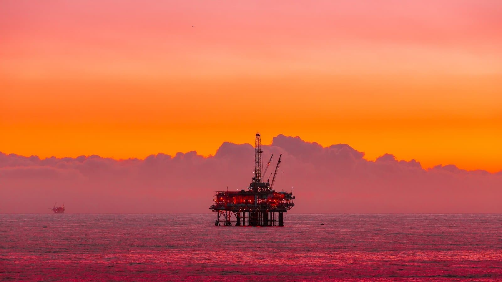Offshore oil rig at sunset over open ocean, representing the produced water volumes that drive disposition decisions across oil and gas operations