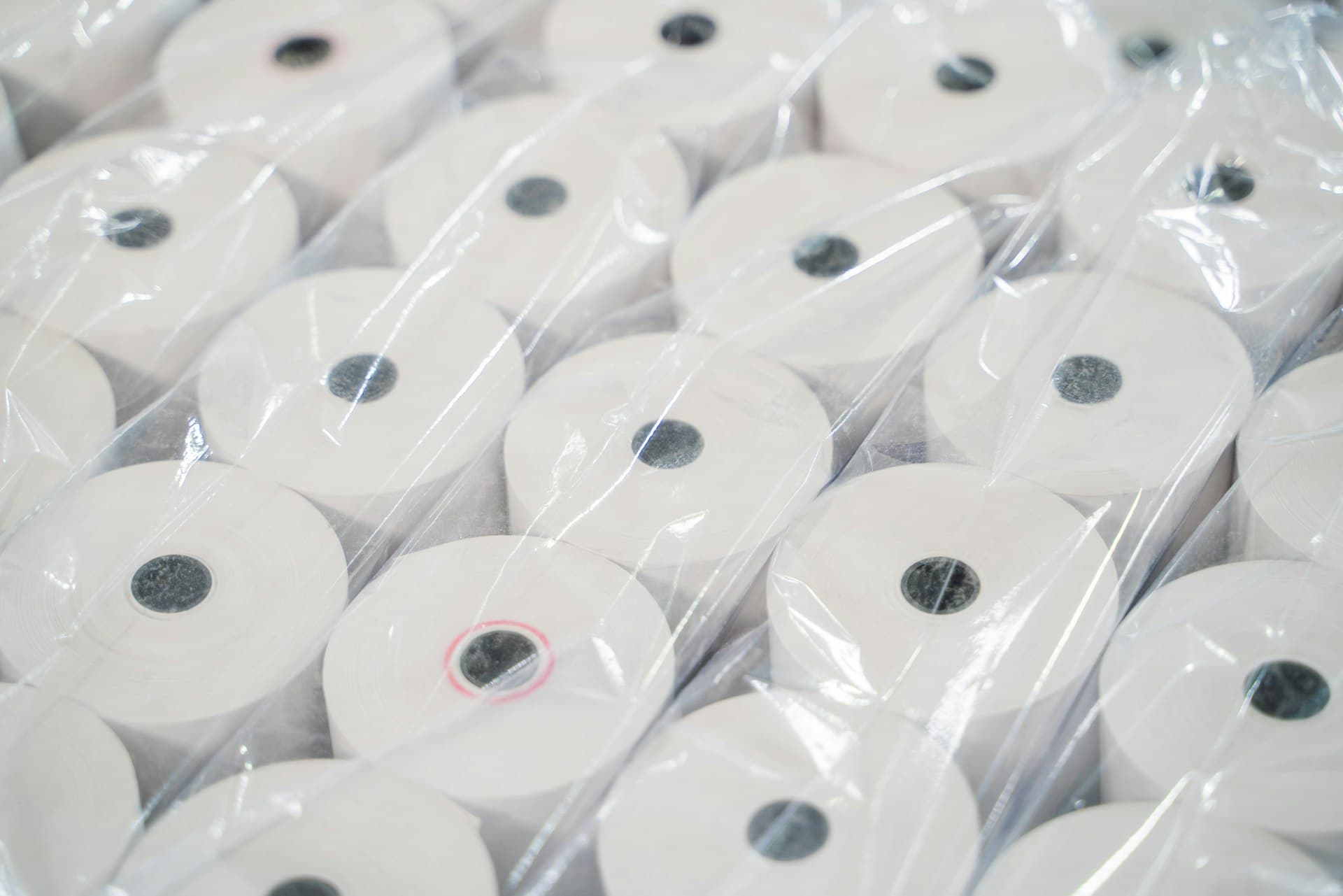 Stacked rolls of finished paper — the water-hungry product of a pulp and paper mill