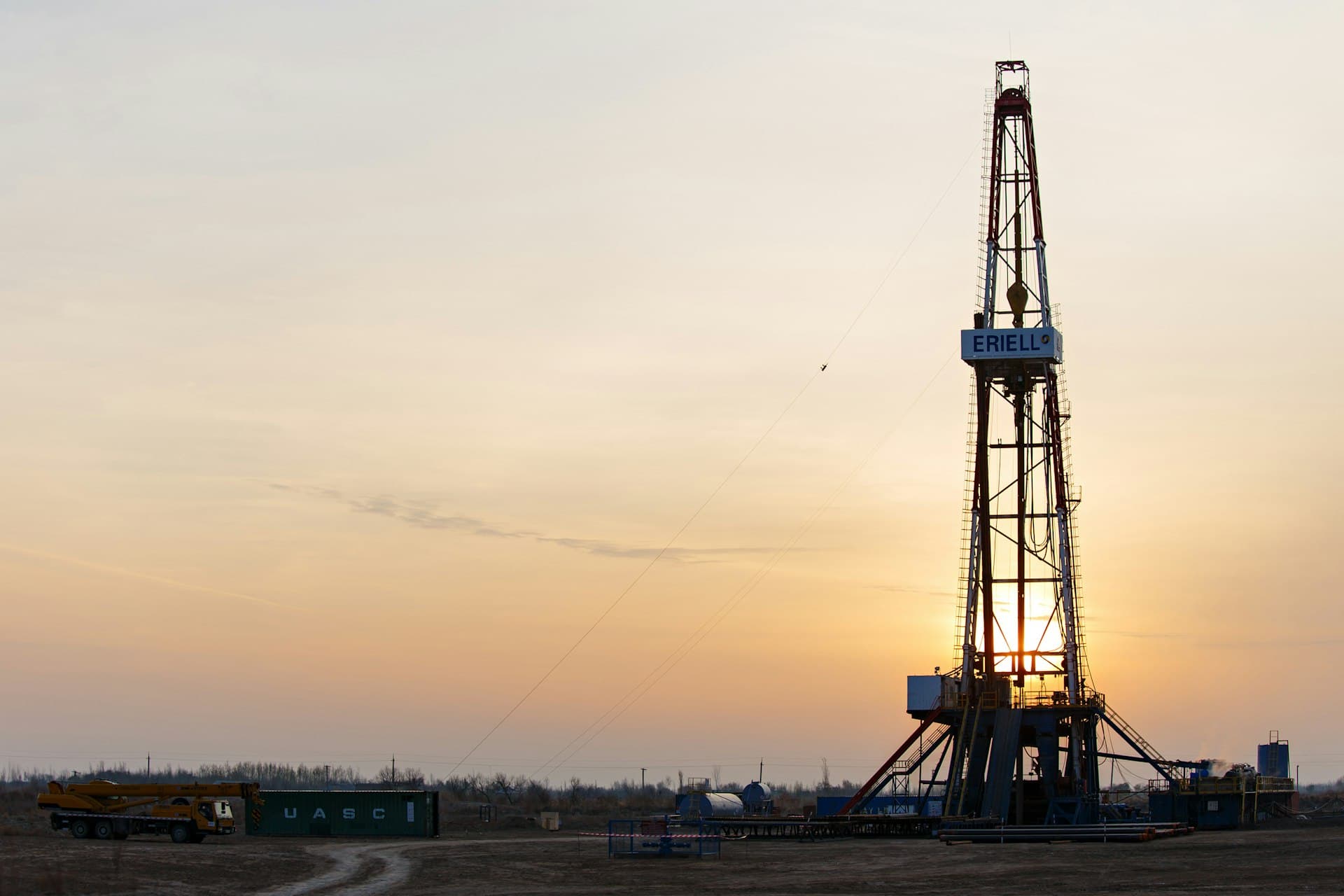 Drilling rig silhouetted at sunset on a shale pad — every well returns flowback water to manage