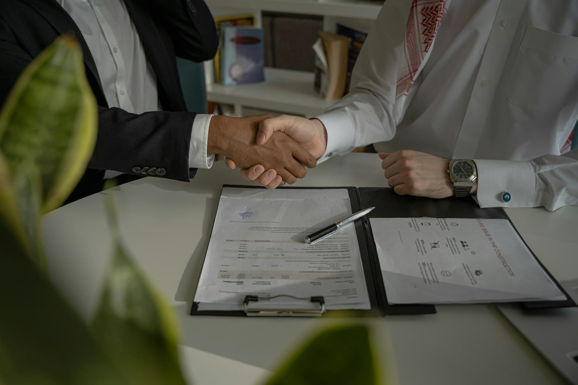 Handshake over a contract on the table — ownership versus service is ultimately a commercial decision