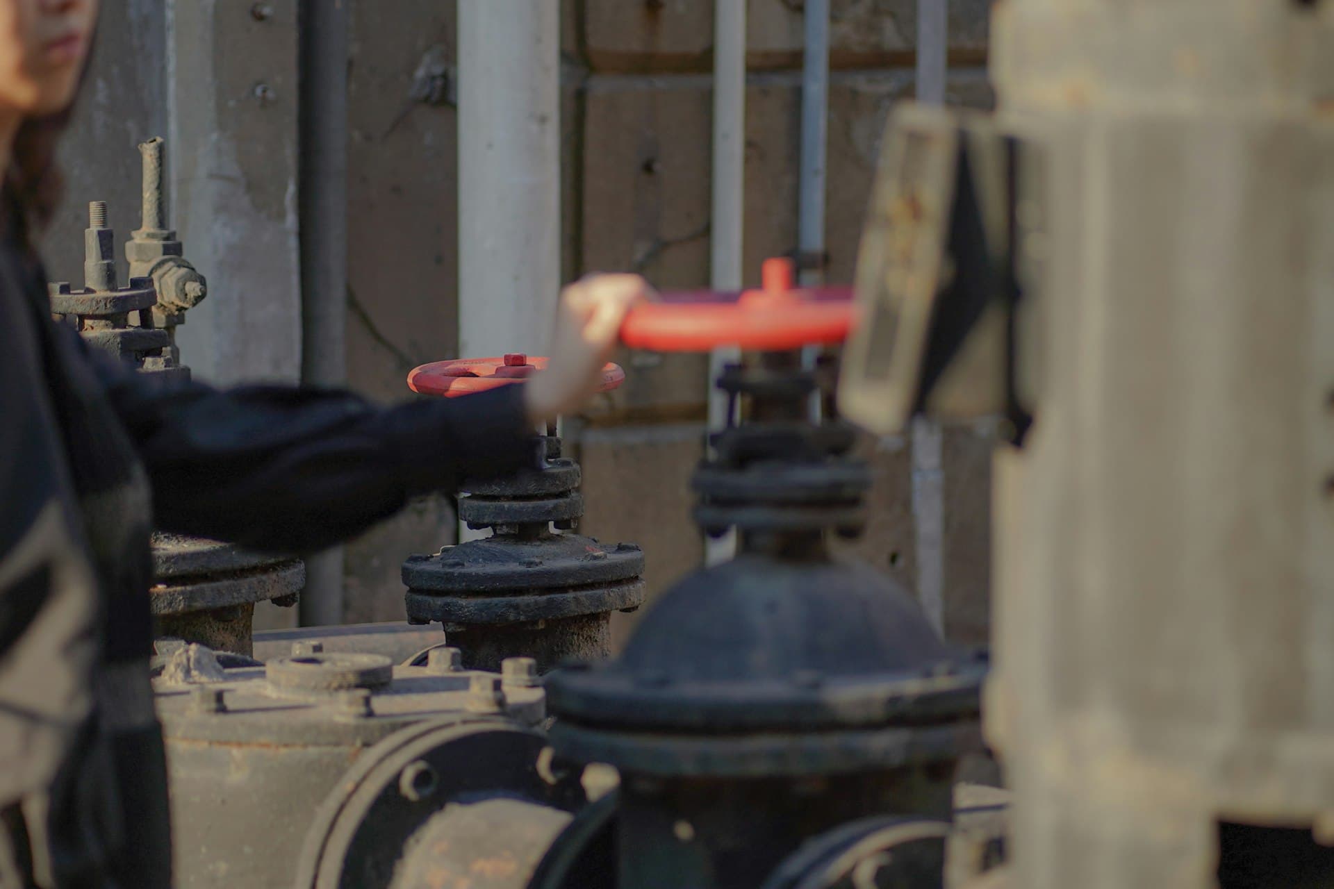 Operator’s gloved hands on a valve — the daily reality of plant operations and maintenance