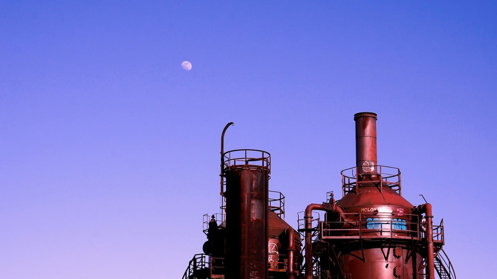 Brown industrial storage tank under a clear blue sky, the civil and mechanical infrastructure that defines water treatment plant design from FEED through to commissioning