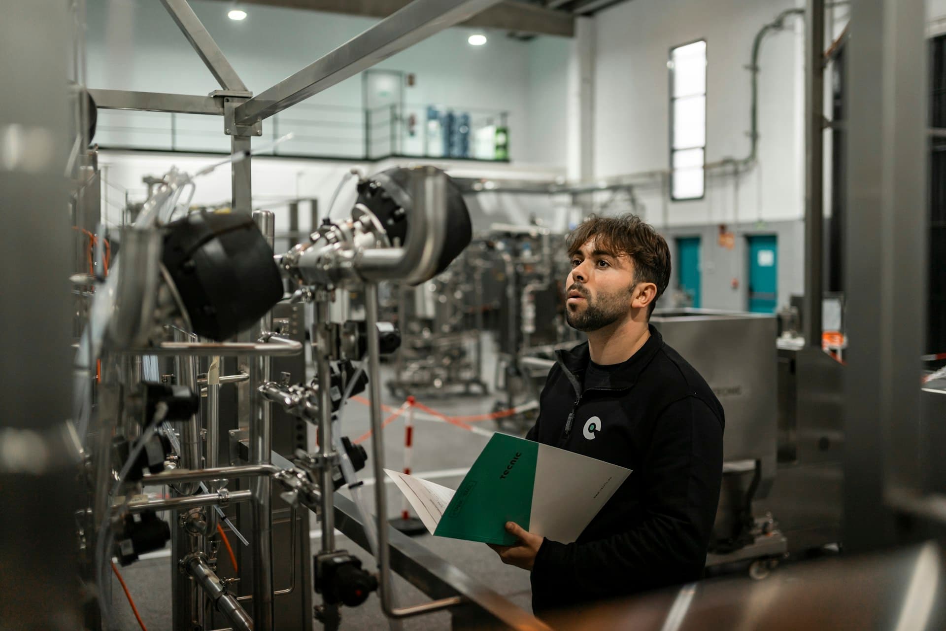 Technician reviewing an industrial piping installation against the check sheet